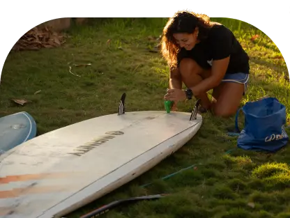 Surfboard rental in El Salvador: preparing a board with fins before a session